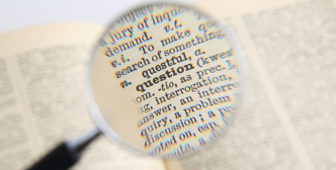 magnifying glass pointed at texts in a dictionary
