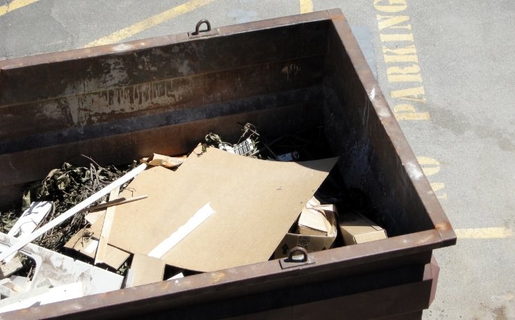 dumpster in big spring filled with variety of trash