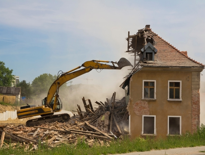 excavator destroying a house