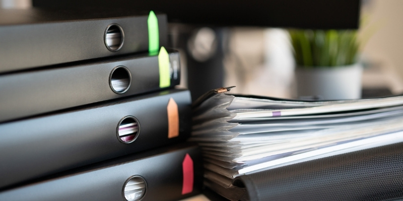 pile of documents in black folders