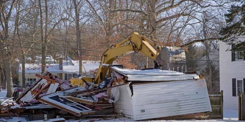 demolition debris being hauled by backhoe