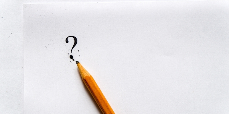 pencil writing question mark on blank paper